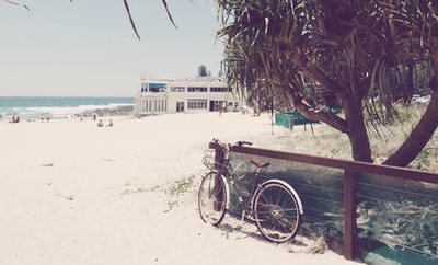 自行车停在海滩附近的木栏杆旁